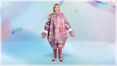 Grayson Perry image - photograph of Grayson in an oversized pink coat on an abstract sky blue background