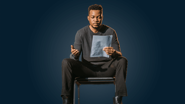 Acting 101 - photo of a man sat down reading a script on a navy blue background