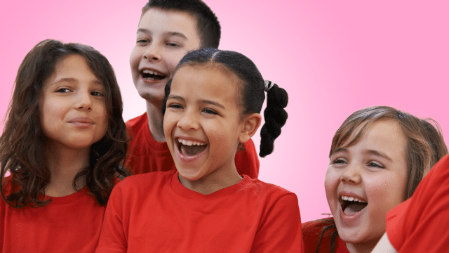 Group of children laughing on pink background