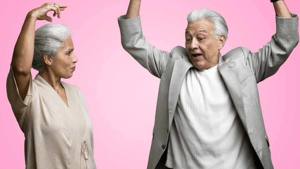 Senior Social Club - An image of two older people dancing on a block pink background