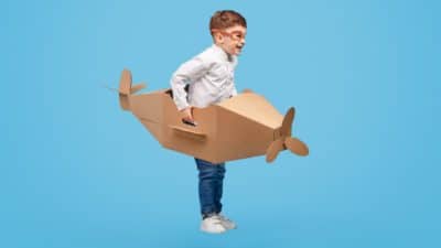 Child playing with a cardboard aeroplane
