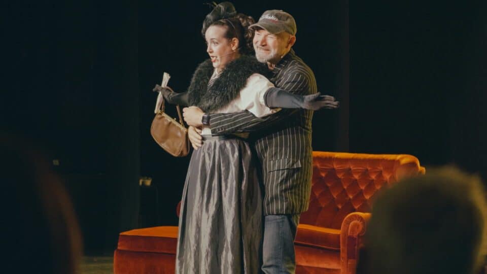 Actor hugging the actress from behind while performing