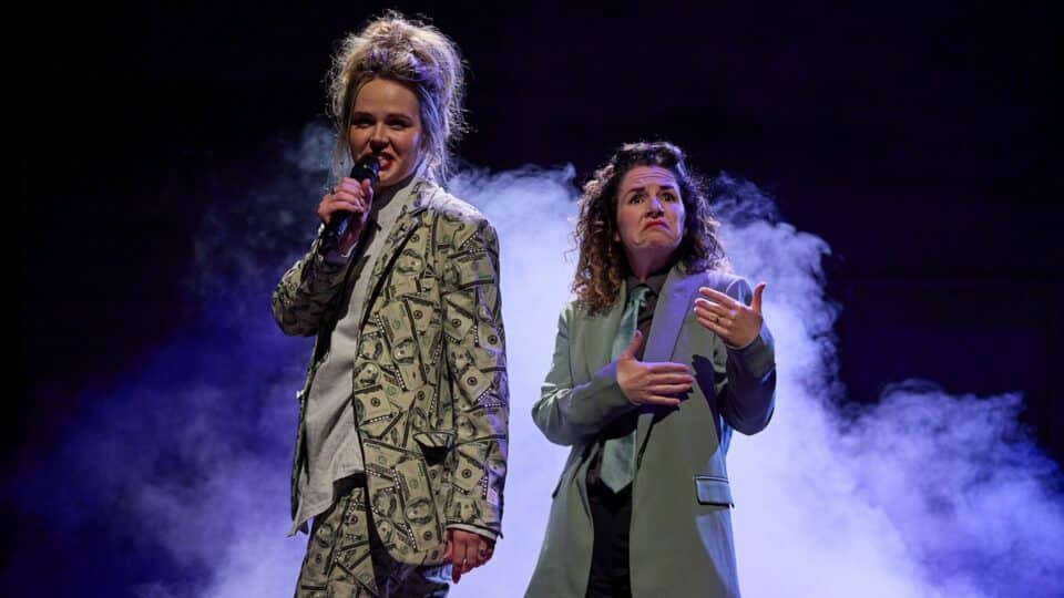 Two women performing. One of them holding a microphone