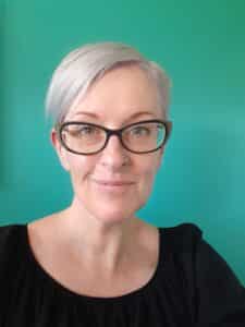 A photo of Lisa Eureka against a bright blue background